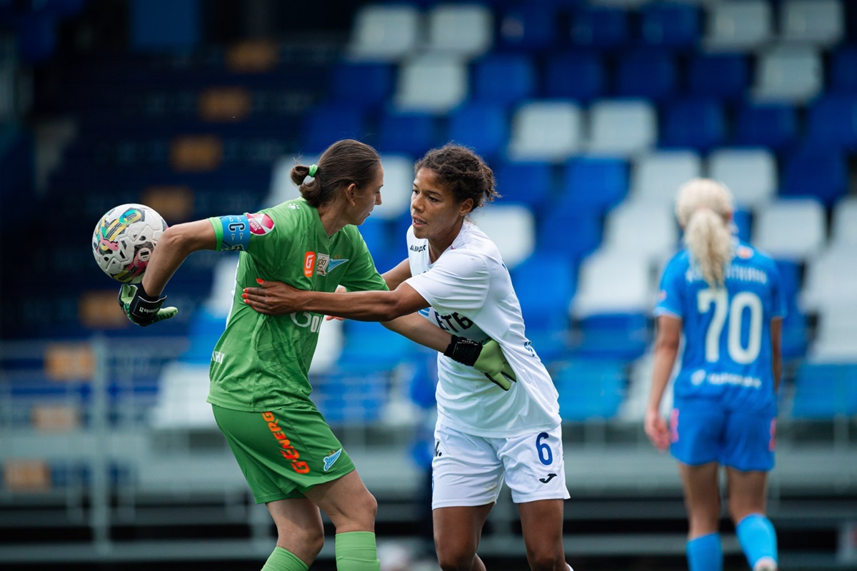 Kaylan Williams just scored a goal and is trying to take the ball away from Zenit goalkeeper Yulia Grichenko to get the game going faster